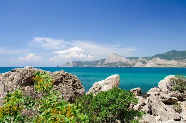 Il litorale roccioso con l'acqua blu trasparente più pura Foto Stock