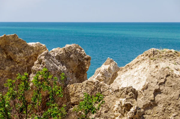 Skalnaté pobřeží s nejčistší vodou transparentní modrá Stock Obrázky