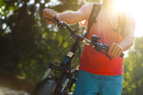 Giovane con bicicletta lungo il fiume di montagna — Foto Stock