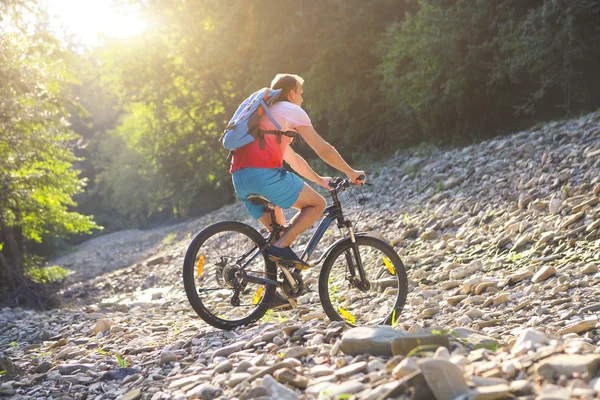 Man on the bicycle by mountain river — Stock Photo, Image