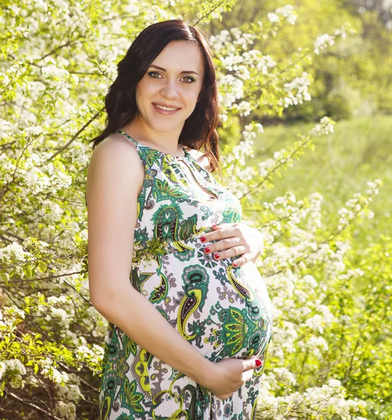 Szép terhes nő zöld ruhában portréja — Stock Fotó