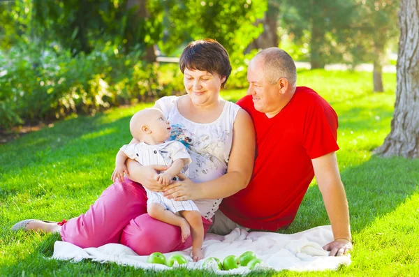 Lycklig familj med pojke i parken — Stockfoto