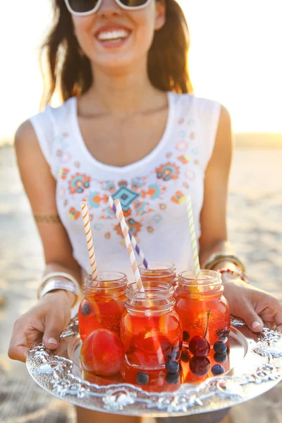 Gelukkig jonge vrouw met een schotel met een drankje aan de partij van de zomer — Stockfoto