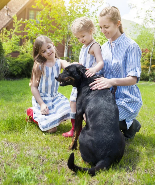 Glad mamma med hennes döttrar med hunden — Stockfoto