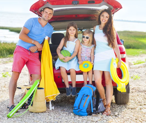 Porträtt av en leende familj med två barn på stranden — Stockfoto