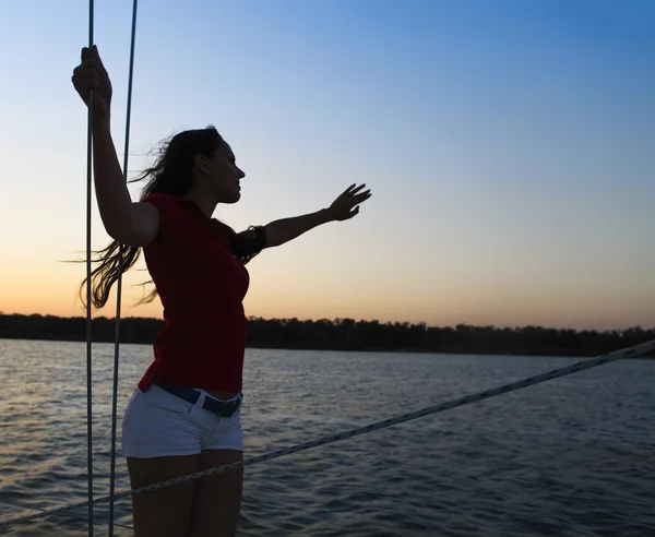 Vacker kvinna på yacht däck i solnedgången ljus — Stockfoto