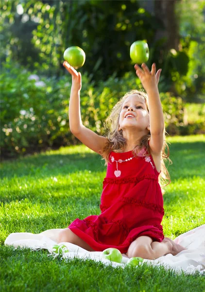 Petite fille drôle avec des pommes vertes — Photo