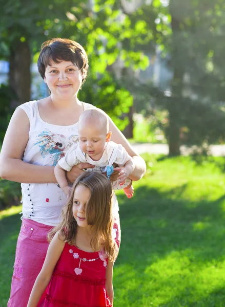 Mamma och hennes barn utomhus. Glad mamma och hennes barn som leker — Stockfoto