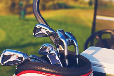 yeşil alan arka plan üzerinde golf kulüpleri sürücüleri