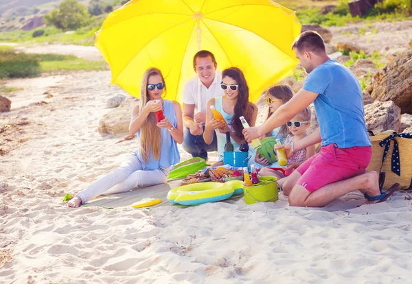 Przyjaciele siedząc na piasku na plaży na letni piknik — Zdjęcie stockowe