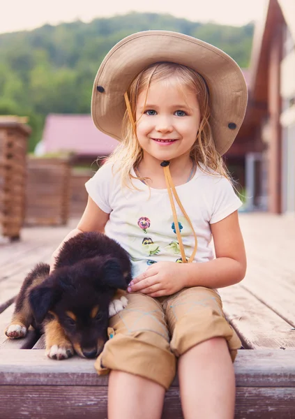 Söt liten flicka kramar hundvalp — Stockfoto