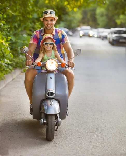 Feliz jovem pai e pequena filha montando uma scooter vintage — Fotografia de Stock