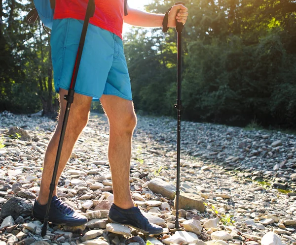 Escursioni uomo con zaino in spalla e bastoni in montagna — Foto Stock