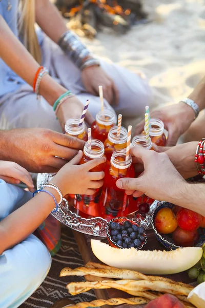 Grupp vänner håller drycker på sommar picknick — Stockfoto