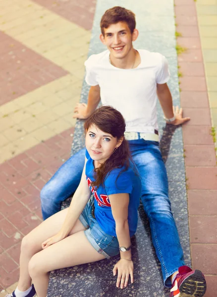 Симпатичные молодые красивые подростки, сидящие в городе возле университета после — стоковое фото