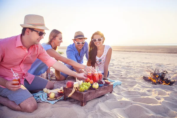 Amigos sentados en la arena en la playa en círculo — Foto de Stock