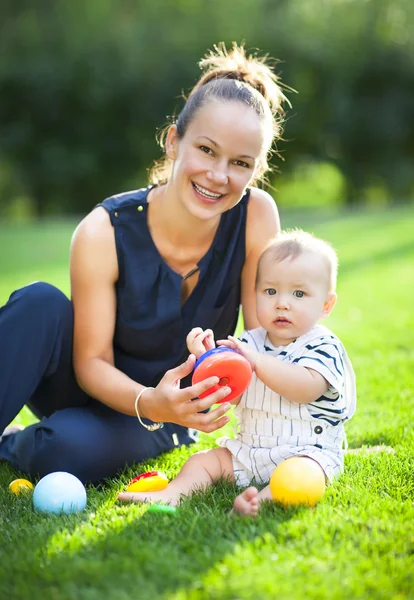 Feliz mamá y su niño jugando en parque juntos — Foto de Stock