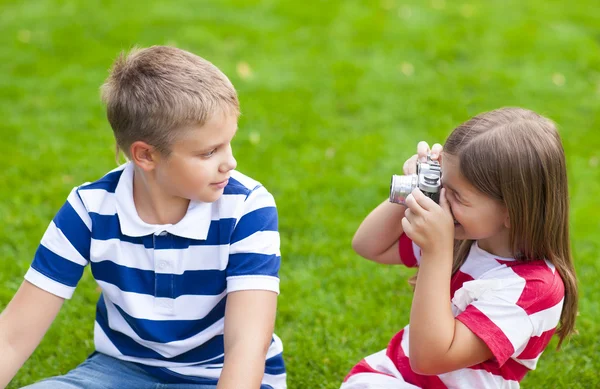 Joli petit frère et soeur jouant avec un appareil photo en été — Photo