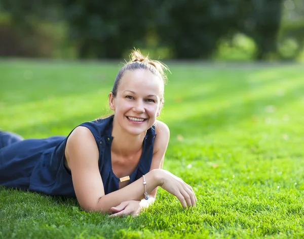 Glada leende kvinna i parken sommaren — Stockfoto