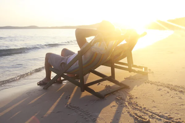 Feliz pareja sentado en sillas de sol en la playa de Koh Samet en — Foto de Stock