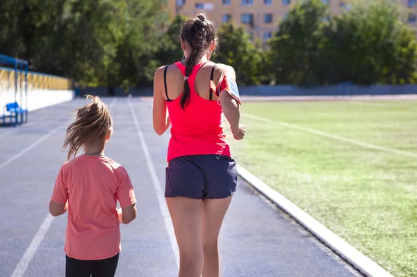 Mère et petite fille font de l'exercice dans le stade — Photo