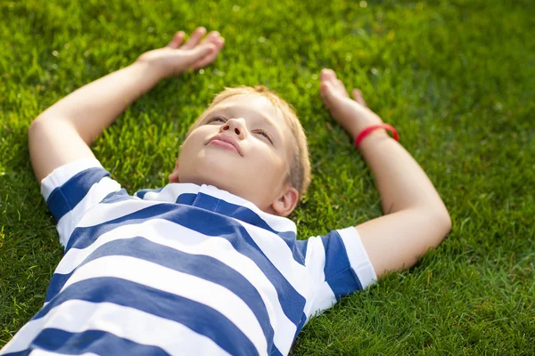 Chlapeček si lehl na trávě — Stock fotografie