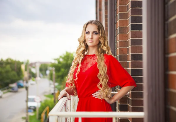 Beautiful blond woman in red long dress — Stock Photo, Image