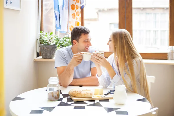 Bonito casal tomando café da manhã juntos n a cozinha — Fotografia de Stock