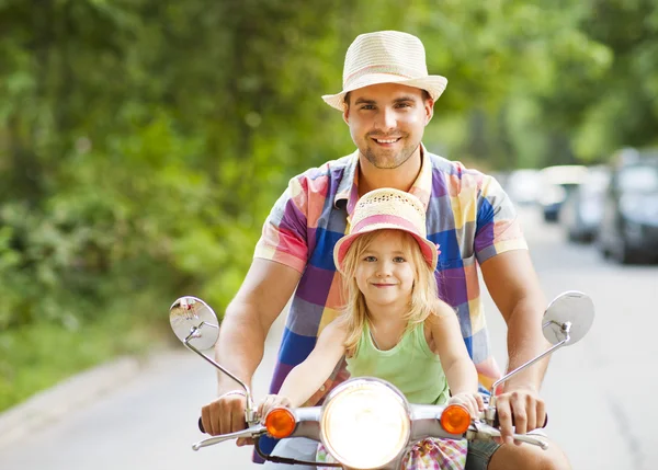Счастливый молодой отец и маленькая дочь катаются на винтажном скутере — стоковое фото