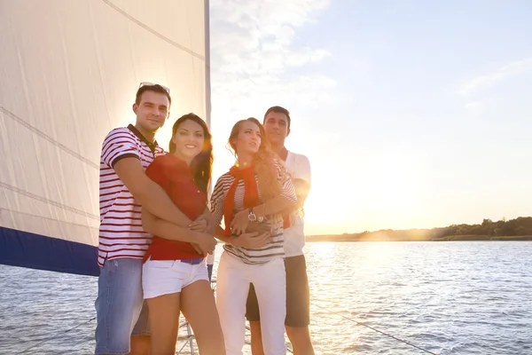 Lächelnde Freunde an Deck der Jacht und Gruß — Stockfoto