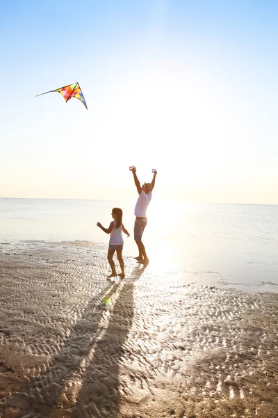 Szczęśliwy młody ojciec z córką z latania latawcem na plaży — Zdjęcie stockowe