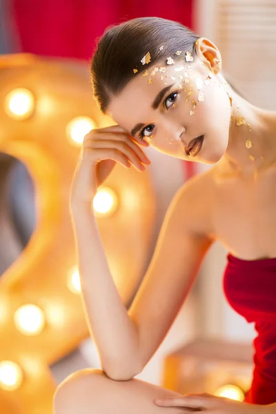 Hermosa joven con brillante maquillaje de oro — Foto de Stock