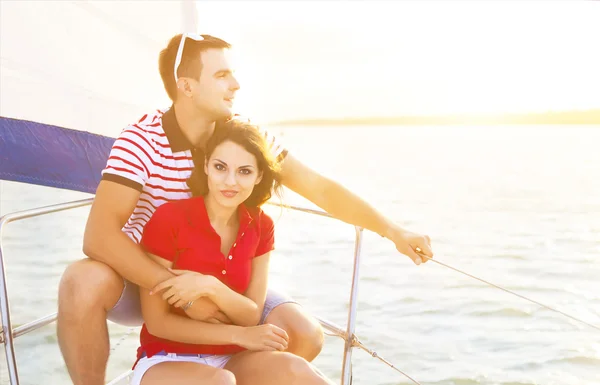 Jovem casal sorridente em um barco à vela no verão — Fotografia de Stock