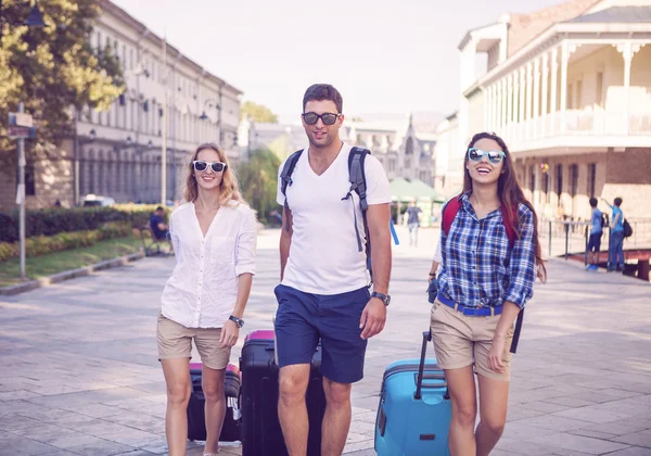 Viajeros amigos con equipaje caminando por la calle de la ciudad —  Fotos de Stock