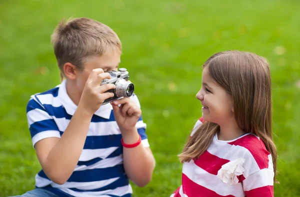 Joli petit frère et soeur jouant avec un appareil photo en été — Photo