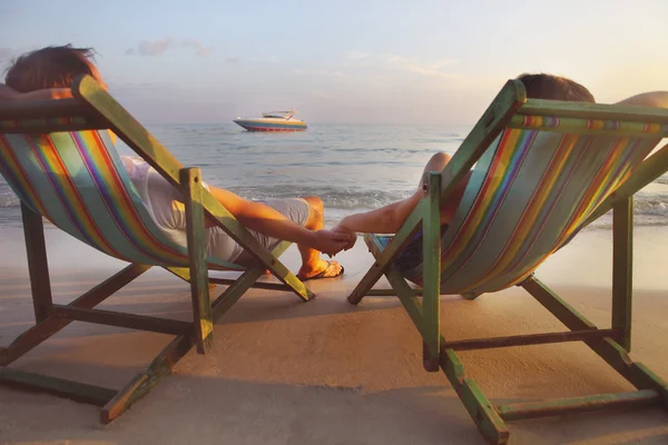 幸せなカップルでコ サメットのビーチに日光浴用の椅子に座って — ストック写真