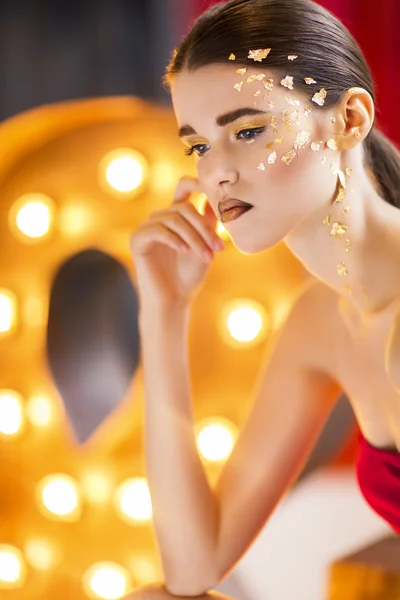 Porträt einer schönen jungen Frau mit leuchtend goldenem Make-up — Stockfoto