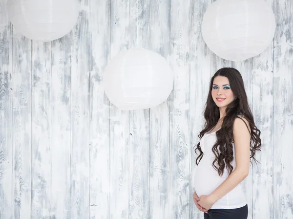 Portrait of beautiful smiling pregnant woman over wooden white b — Stock Photo, Image