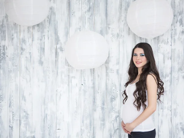 Retrato de hermosa mujer embarazada sonriente sobre blanco de madera b —  Fotos de Stock