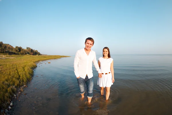 Unga lyckliga par i kärlek vid havet i sommardag — Stockfoto
