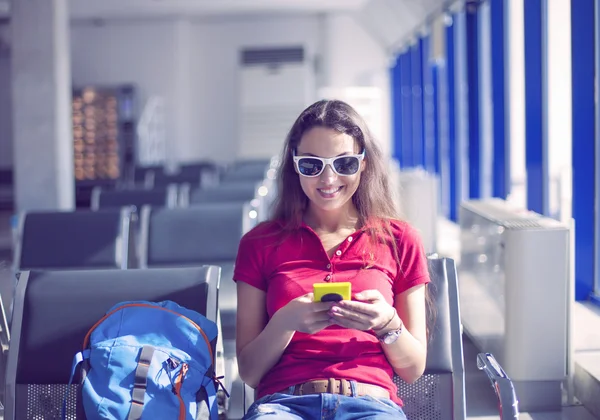 Junge Passagierin mit Smartphone am Gate wartet in Terminal — Stockfoto