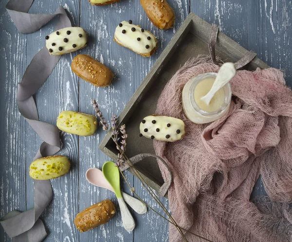 Eclairs with chocolate and whipped cream on dark background — Stock Photo, Image