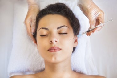 Genç güzel kadın kozmetik enjeksiyon gibi yüzüne almak bir