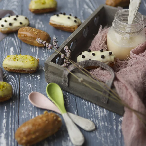 Eclairs with chocolate and whipped cream on dark background — Stock Photo, Image