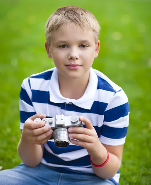 Щасливий усміхнений маленький хлопчик з ретро старовинною камерою — стокове фото