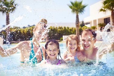 Yüzme havuzunda eğleniyor iki çocuklu aile