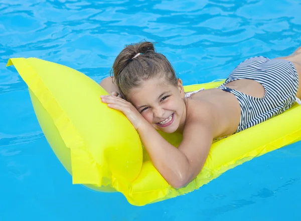 Маленькая девочка плавает на надувном пляжном матрасе — стоковое фото