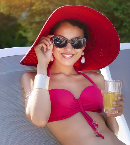 Jonge modieuze vrouw in rode hoed poseren in een rode bikini — Stockfoto
