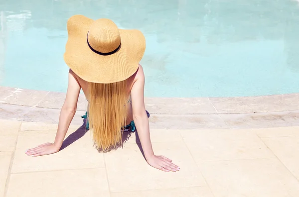 Jeune femme dans le chapeau près de la piscine — Photo
