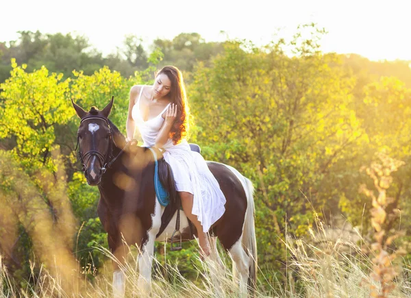 Ung kvinna rider en häst — Stockfoto